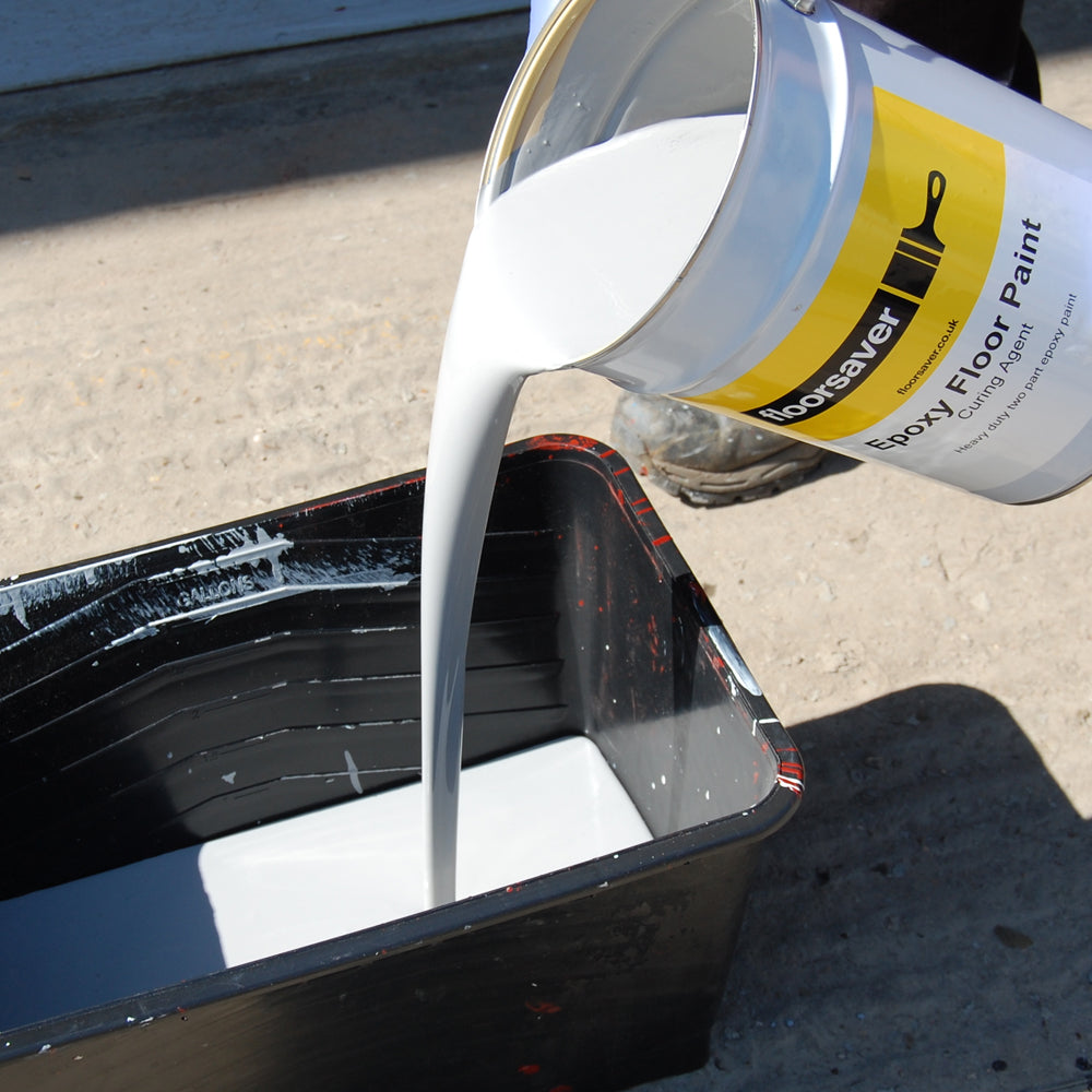 Pouring Epoxy Floor Paint into mixing tub